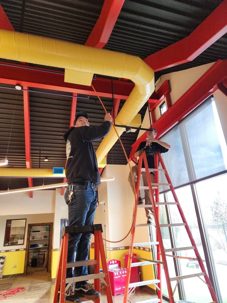 Two Air Duct Cleaning Technicians from Planet Duct cleaning a restaurant's ducts