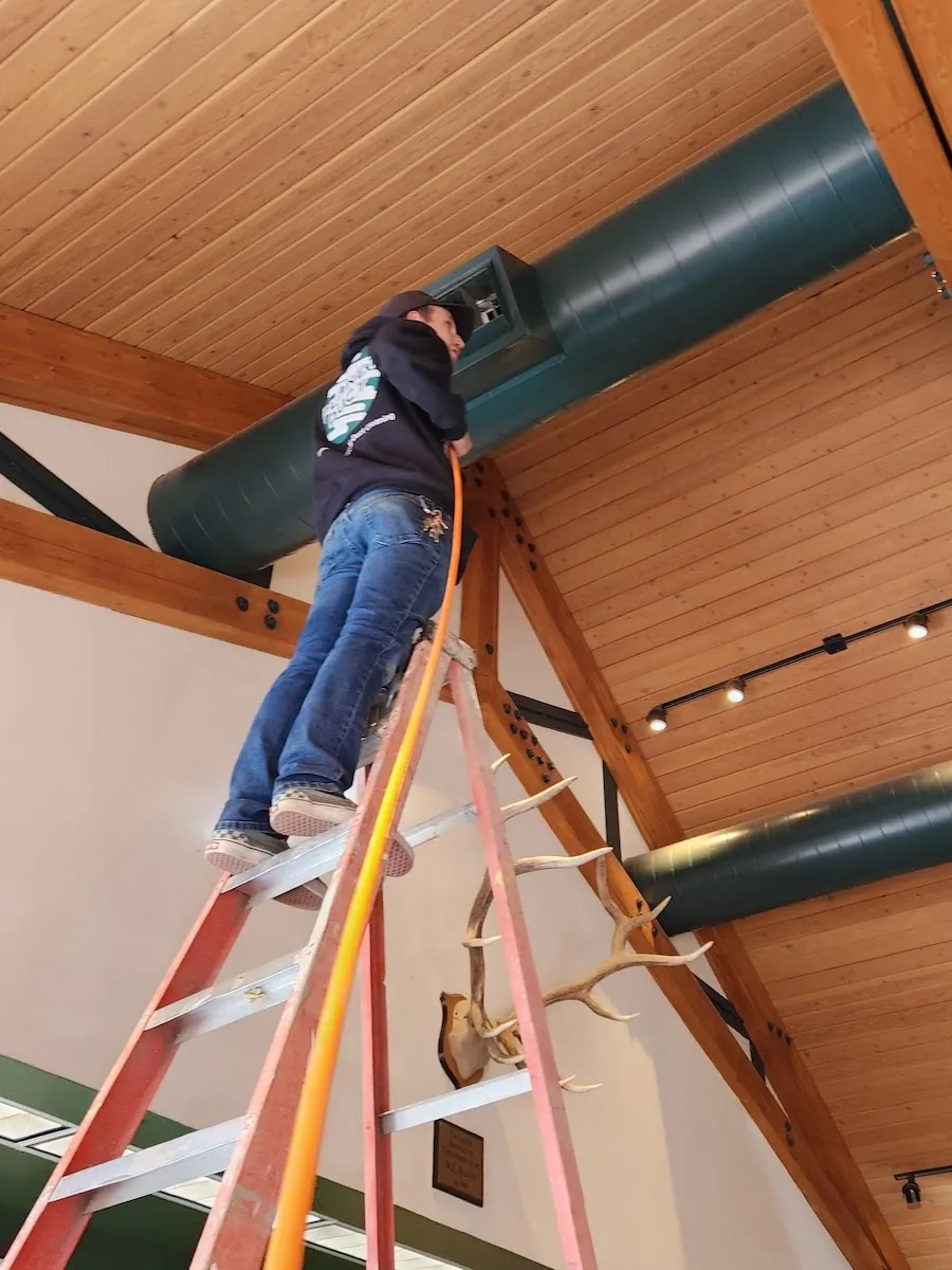 Planet Duct air duct cleaner inspecting commercial air ducts in a vaulted ceiling