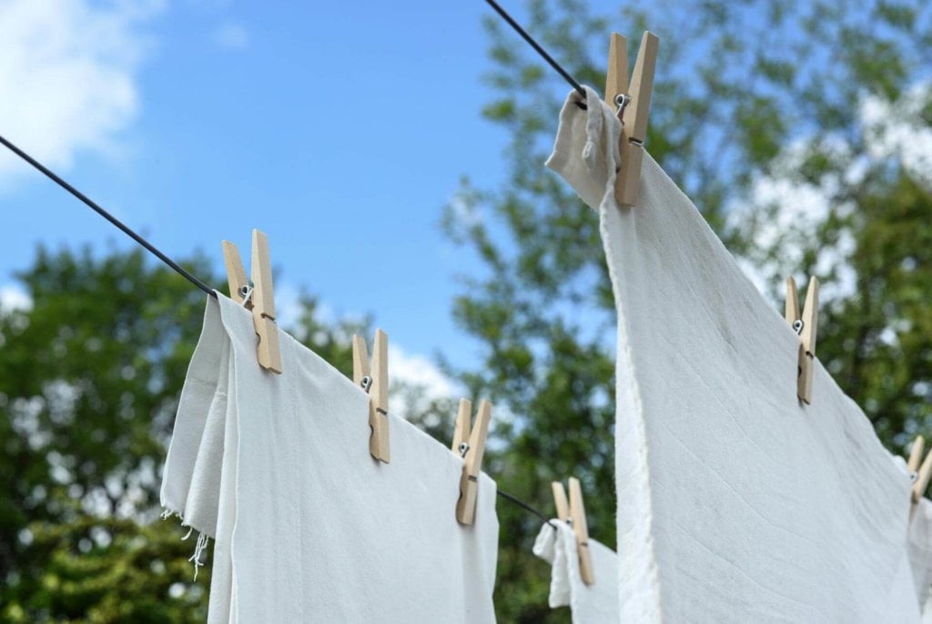 White sheets hanging from a clothesline.
