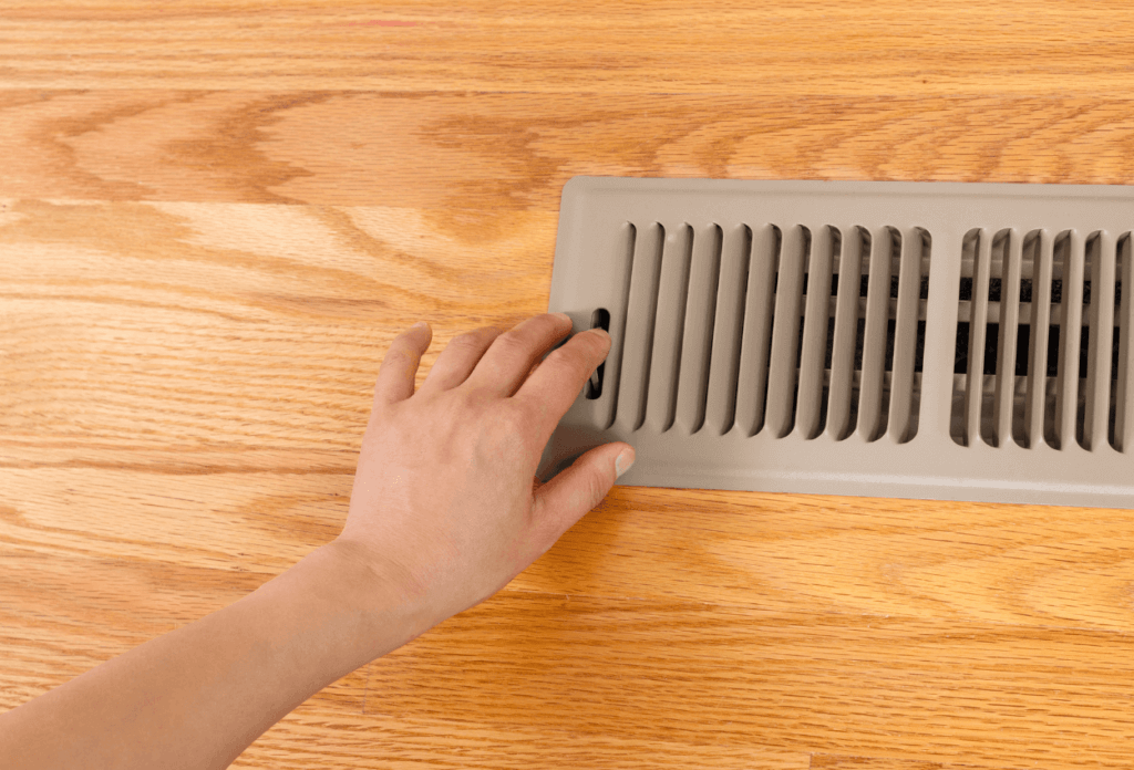 A person's hand by an HVAC vent